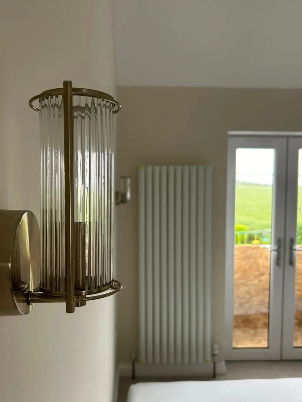 Bedroom wall light and vertical radiator after a full house rewire in Kington